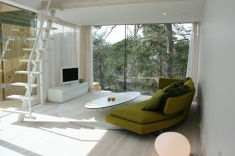 Источник вдохновения для домашнего уюта: открытая гостиная комната среднего размера в скандинавском стиле с белыми стенами, светлым паркетным полом, отдельно стоящим телевизором, угловым камином и фасадом камина из бетона