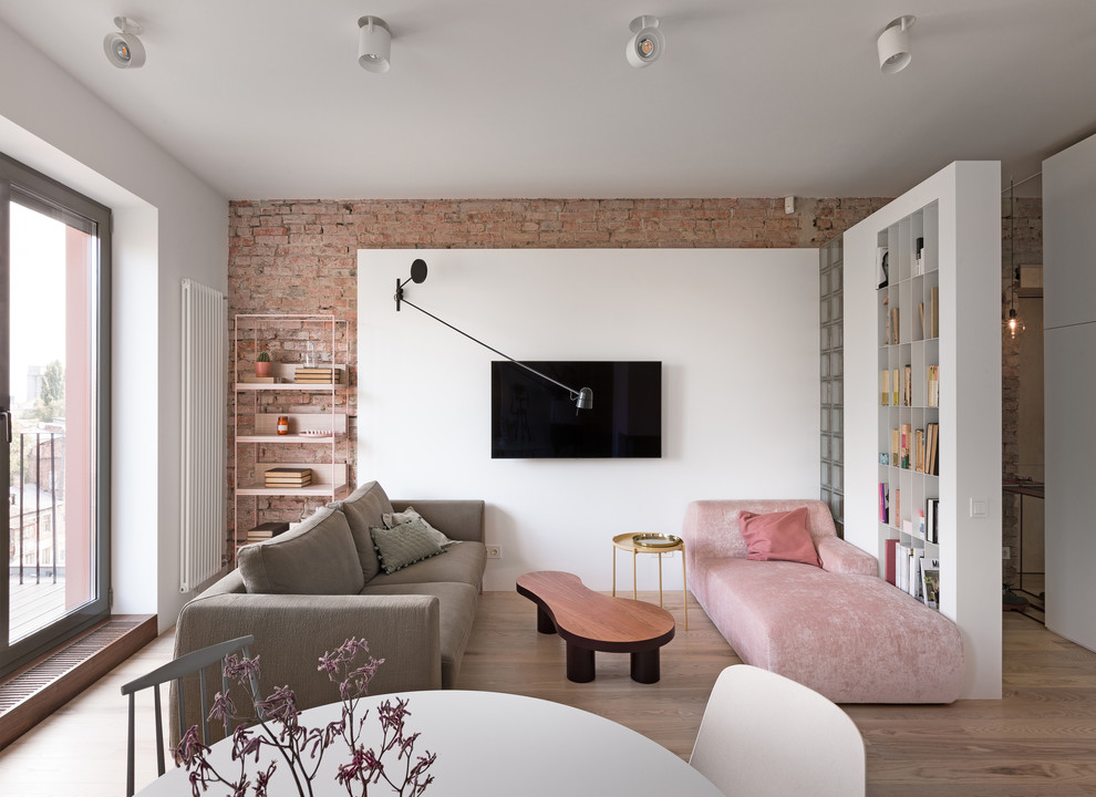 Diseño de salón abierto escandinavo con paredes blancas, suelo de madera en tonos medios, televisor colgado en la pared y suelo marrón