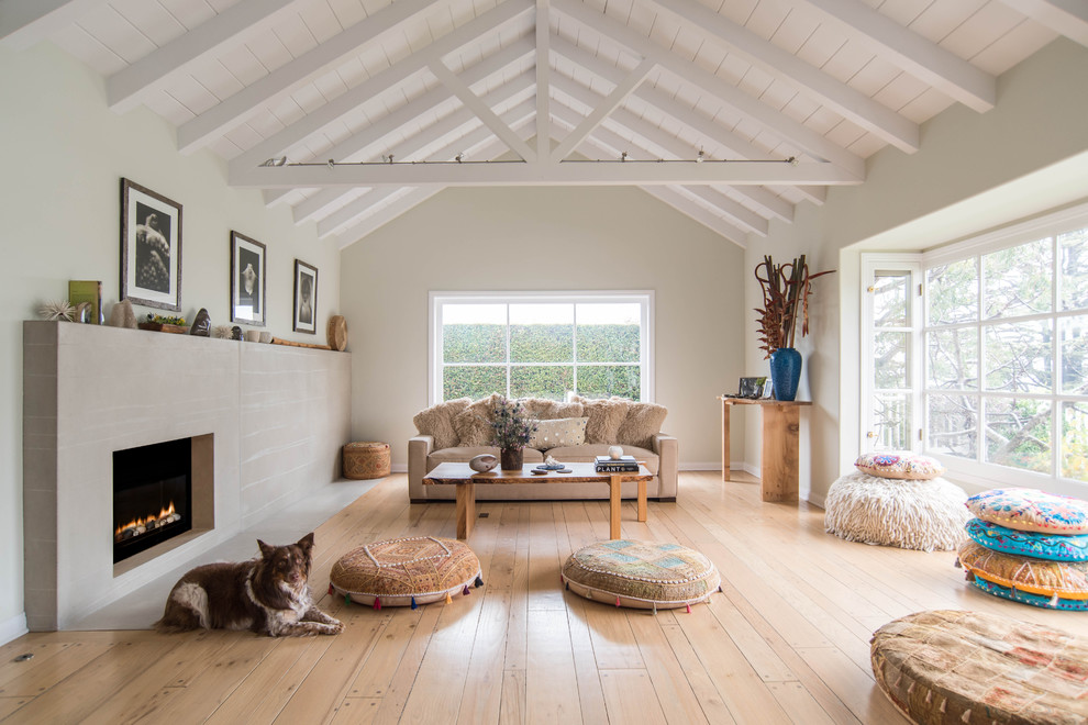 Medium sized scandi open plan living room in Los Angeles with light hardwood flooring, a standard fireplace, no tv, white walls, brown floors and a concrete fireplace surround.