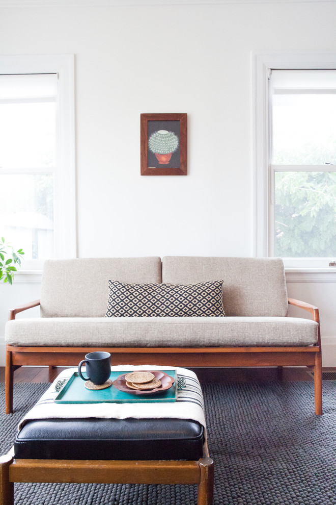 This is an example of a scandi living room in Los Angeles with white walls and carpet.