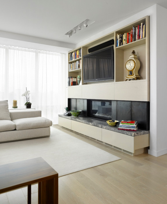 This is an example of a large scandinavian open plan living room in Toronto with white walls, light hardwood flooring, a standard fireplace and a built-in media unit.