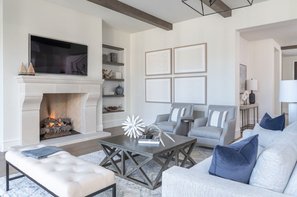 Immagine di un soggiorno stile marinaro con pareti bianche, pavimento in legno massello medio, camino classico, TV a parete e pavimento marrone