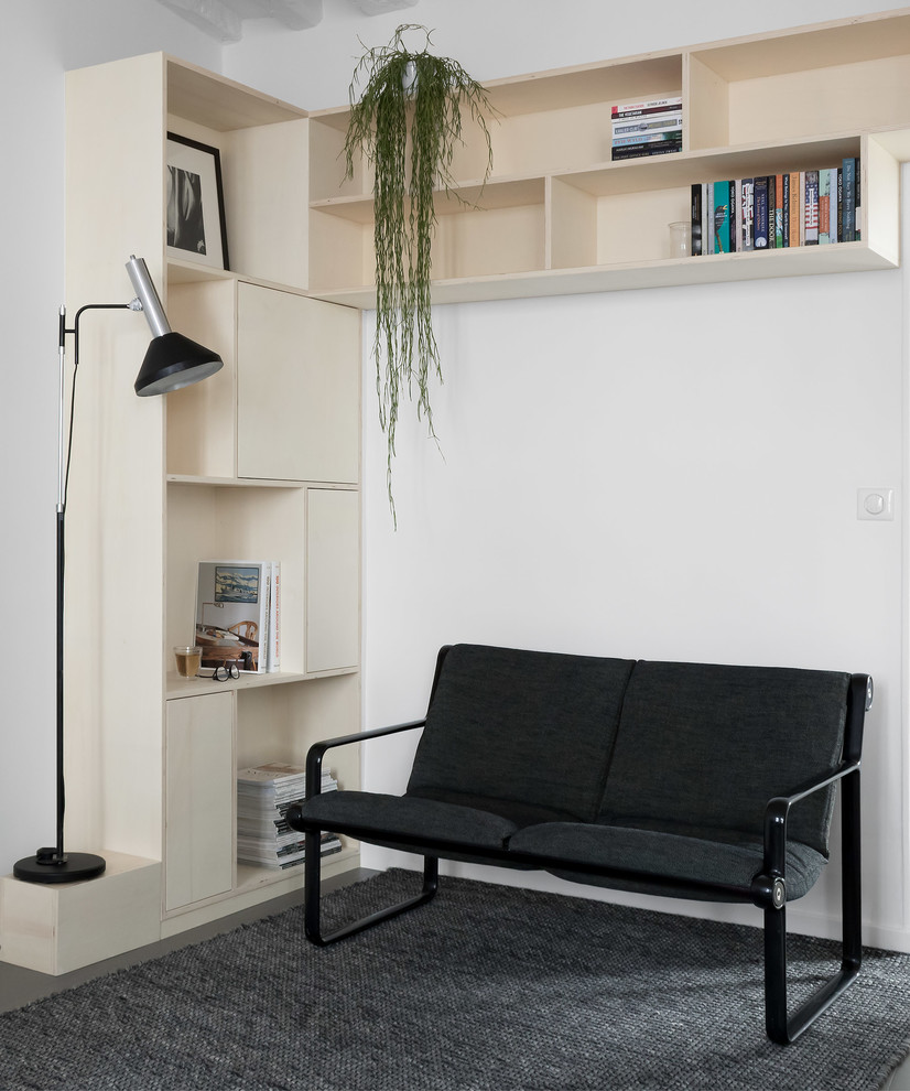 Ejemplo de biblioteca en casa abierta escandinava de tamaño medio con paredes blancas, suelo de madera en tonos medios y suelo gris