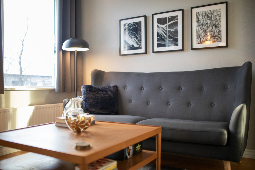 Ejemplo de salón para visitas abierto escandinavo pequeño sin chimenea y televisor con paredes grises, suelo de madera clara y suelo amarillo