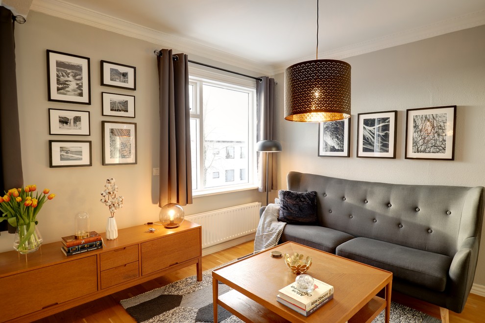 Idee per un piccolo soggiorno scandinavo stile loft con sala formale, pareti grigie, nessuna TV, pavimento giallo e parquet chiaro