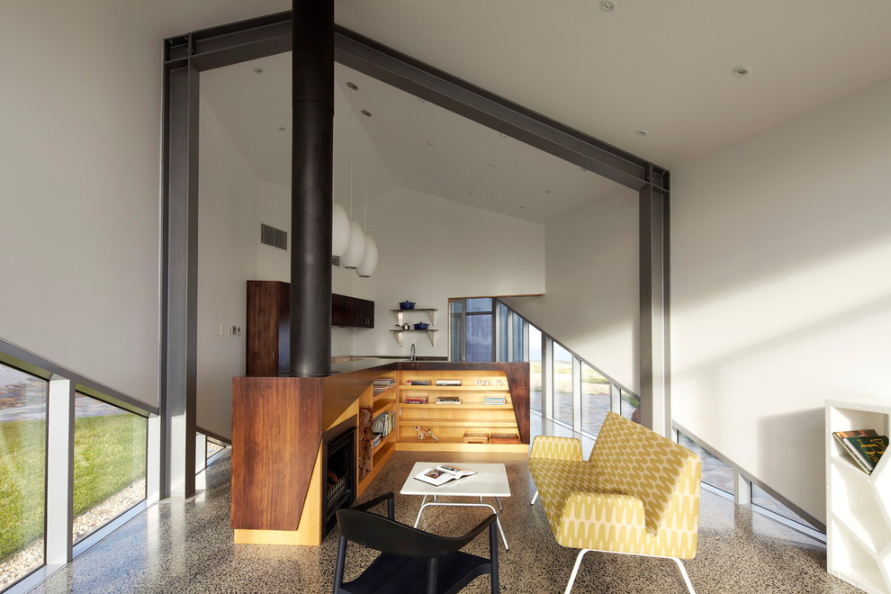 Идея дизайна: открытая гостиная комната среднего размера в современном стиле с белыми стенами, бетонным полом, стандартным камином и фасадом камина из дерева