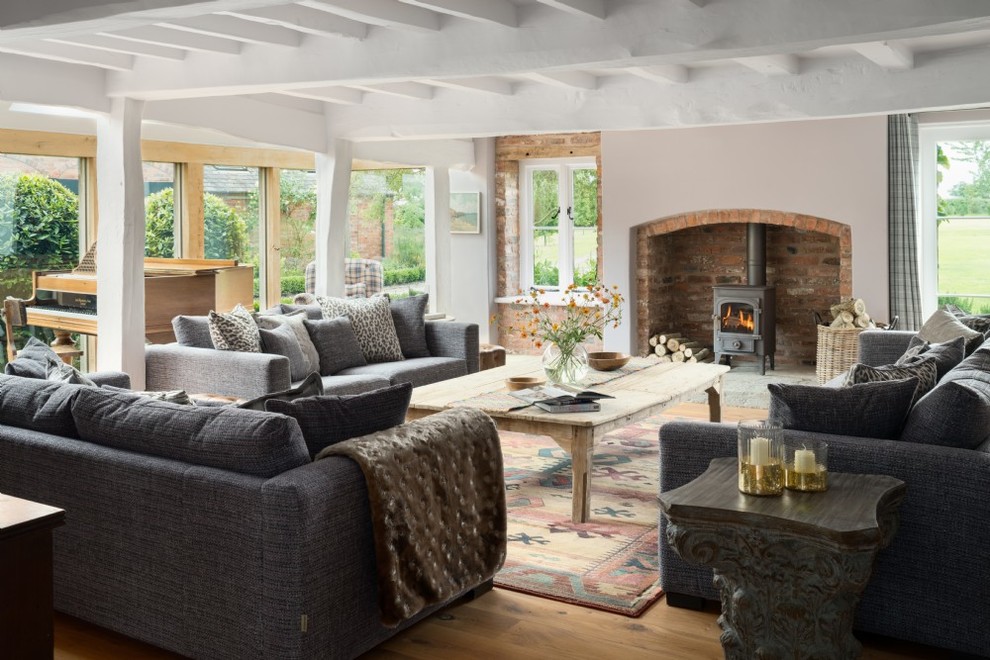 Mittelgroßes, Abgetrenntes Landhaus Wohnzimmer mit beiger Wandfarbe, hellem Holzboden, Kaminofen und beigem Boden in Cheshire