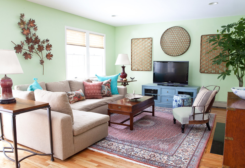Foto de salón abierto bohemio de tamaño medio sin chimenea con paredes verdes, suelo de madera clara y televisor independiente