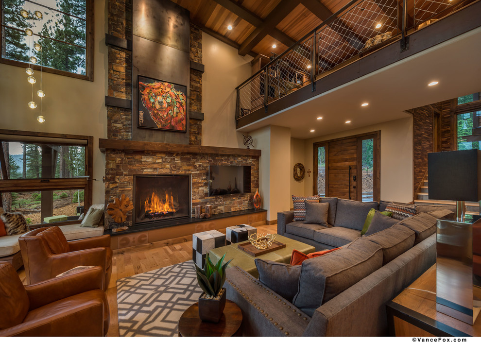 Inspiration for a medium sized industrial mezzanine living room in Sacramento with beige walls, medium hardwood flooring, a standard fireplace, a stone fireplace surround and a wall mounted tv.