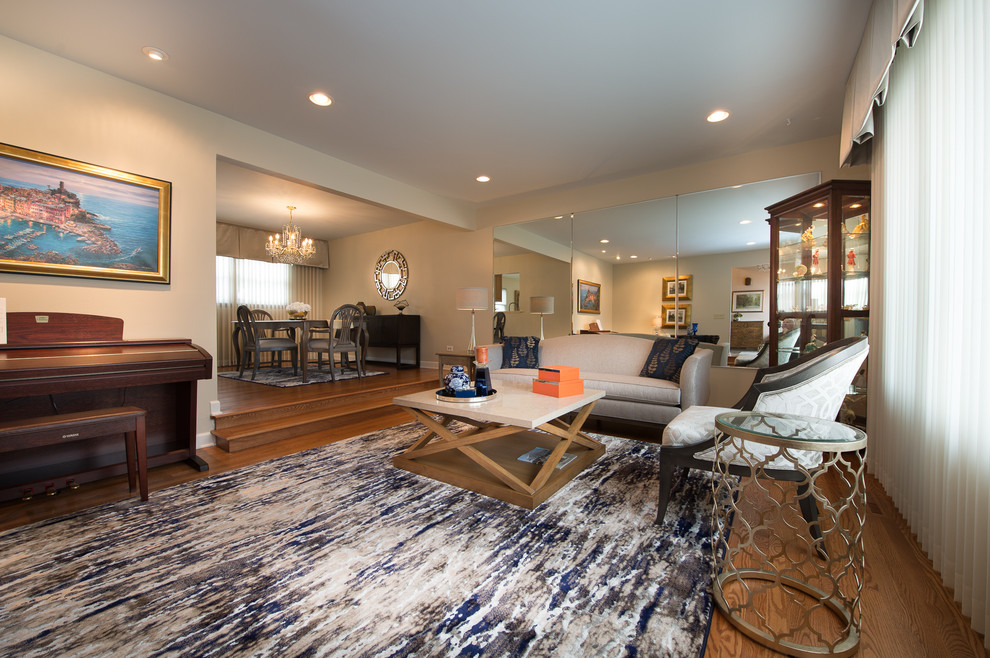 Immagine di un grande soggiorno chic aperto con pareti beige e pavimento in legno massello medio
