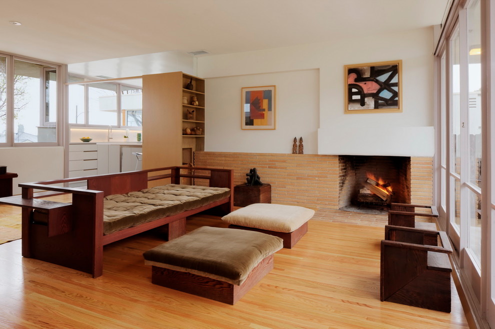 1950s open concept light wood floor living room photo in Los Angeles with a standard fireplace and a brick fireplace