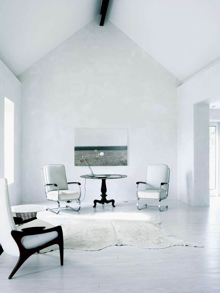 Idée de décoration pour un salon nordique avec un mur blanc et parquet clair.