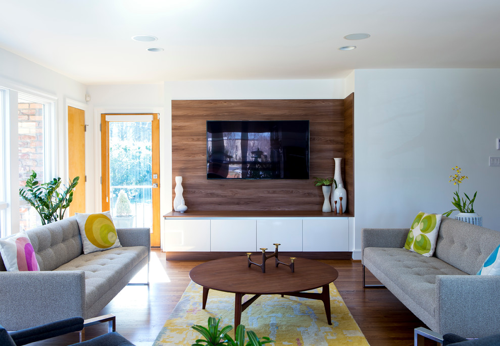 Aménagement d'un salon moderne ouvert avec un mur blanc, un sol en bois brun, aucune cheminée et un téléviseur fixé au mur.