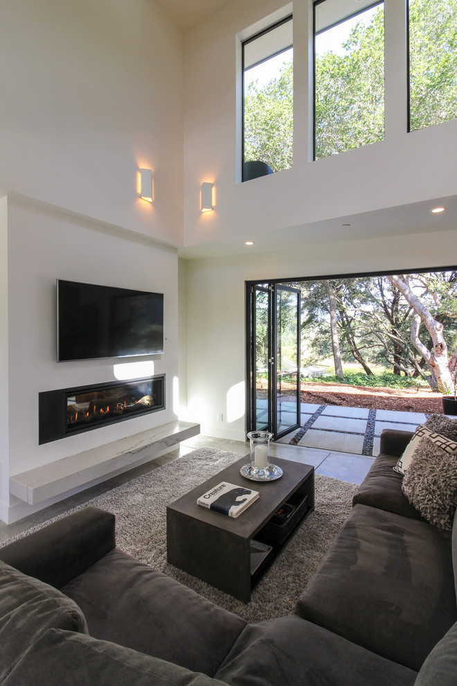 Large minimalist open concept concrete floor and gray floor living room photo in San Francisco with white walls, a standard fireplace, a metal fireplace and a wall-mounted tv