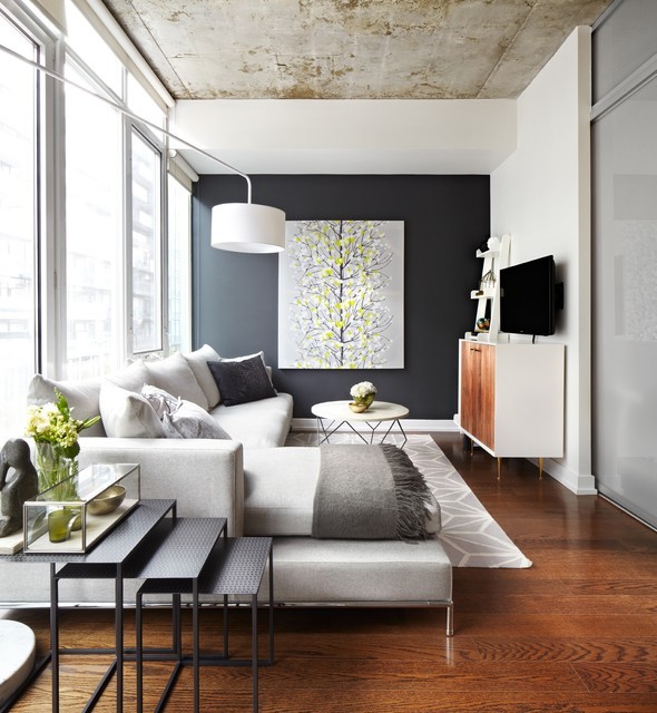 Cette photo montre un petit salon mansardé ou avec mezzanine éclectique avec un mur blanc, un téléviseur fixé au mur, un sol en bois brun et éclairage.