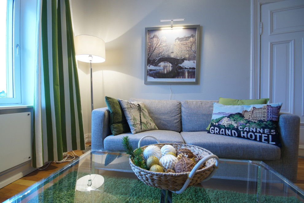 Foto på ett litet funkis separat vardagsrum, med ett finrum, grå väggar, mellanmörkt trägolv, en öppen vedspis, en spiselkrans i betong och en fristående TV