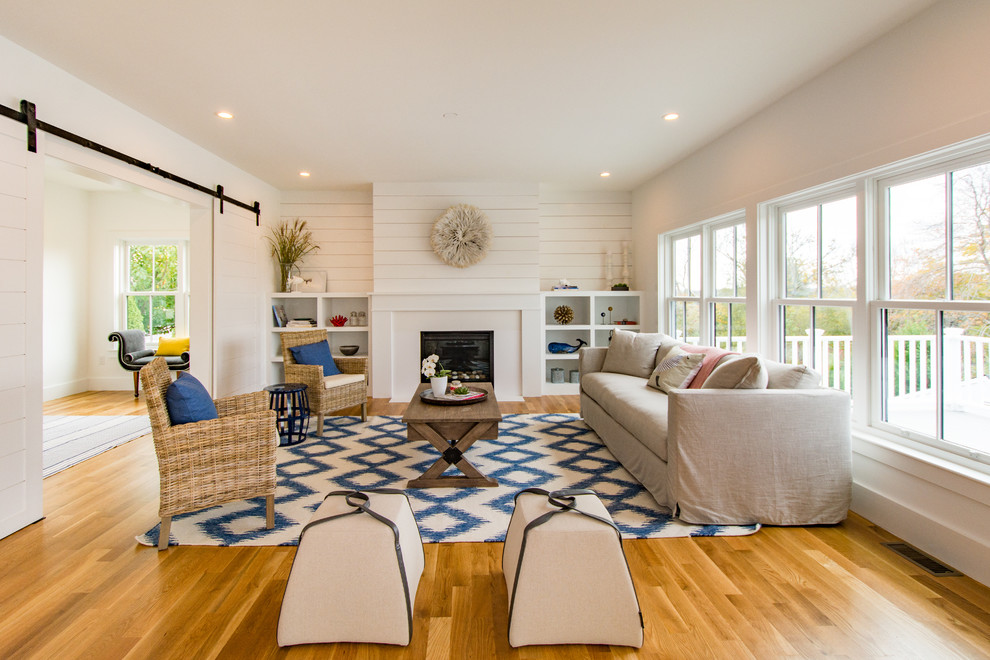 Abgetrenntes Landhausstil Wohnzimmer mit weißer Wandfarbe, Kamin und braunem Holzboden in Boston