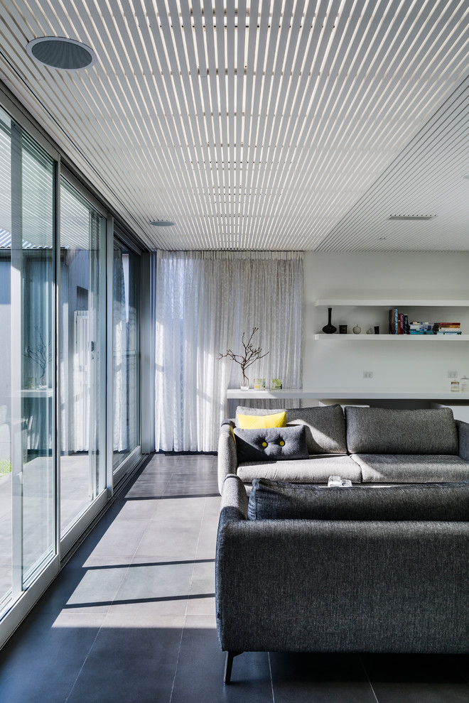 Idee per un soggiorno design con pareti bianche e TV a parete