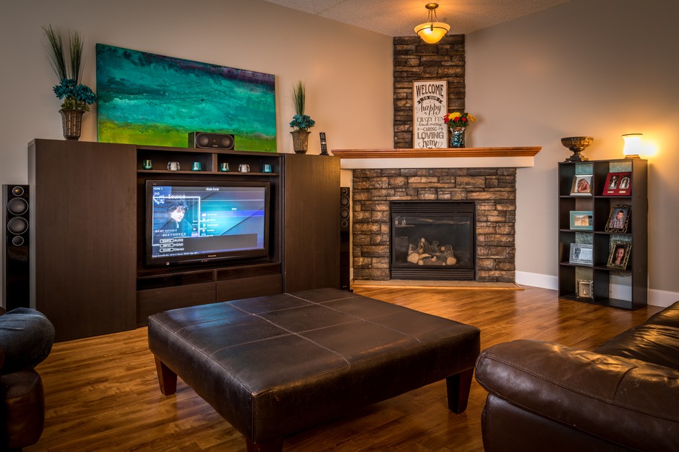 Example of a mid-sized transitional enclosed dark wood floor and brown floor living room design in Calgary with beige walls, a concealed tv, a corner fireplace and a stone fireplace