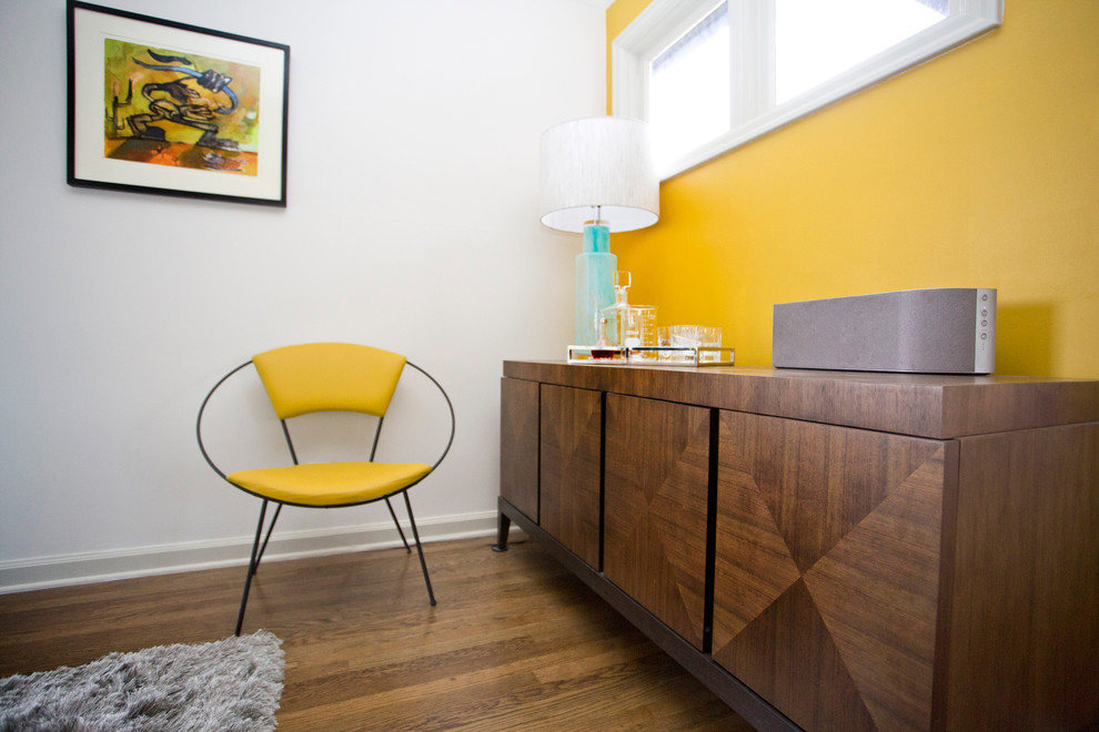 Idée de décoration pour un salon vintage de taille moyenne et fermé avec un mur jaune, un sol marron et un sol en bois brun.