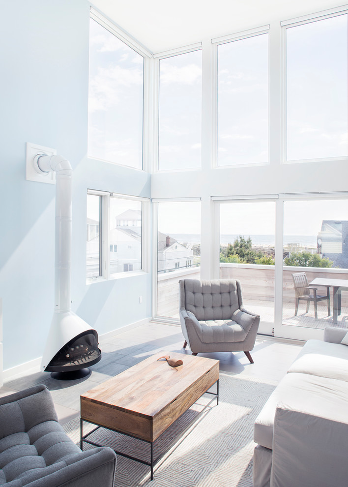 Ispirazione per un soggiorno minimalista di medie dimensioni e aperto con pareti blu, parquet chiaro e stufa a legna
