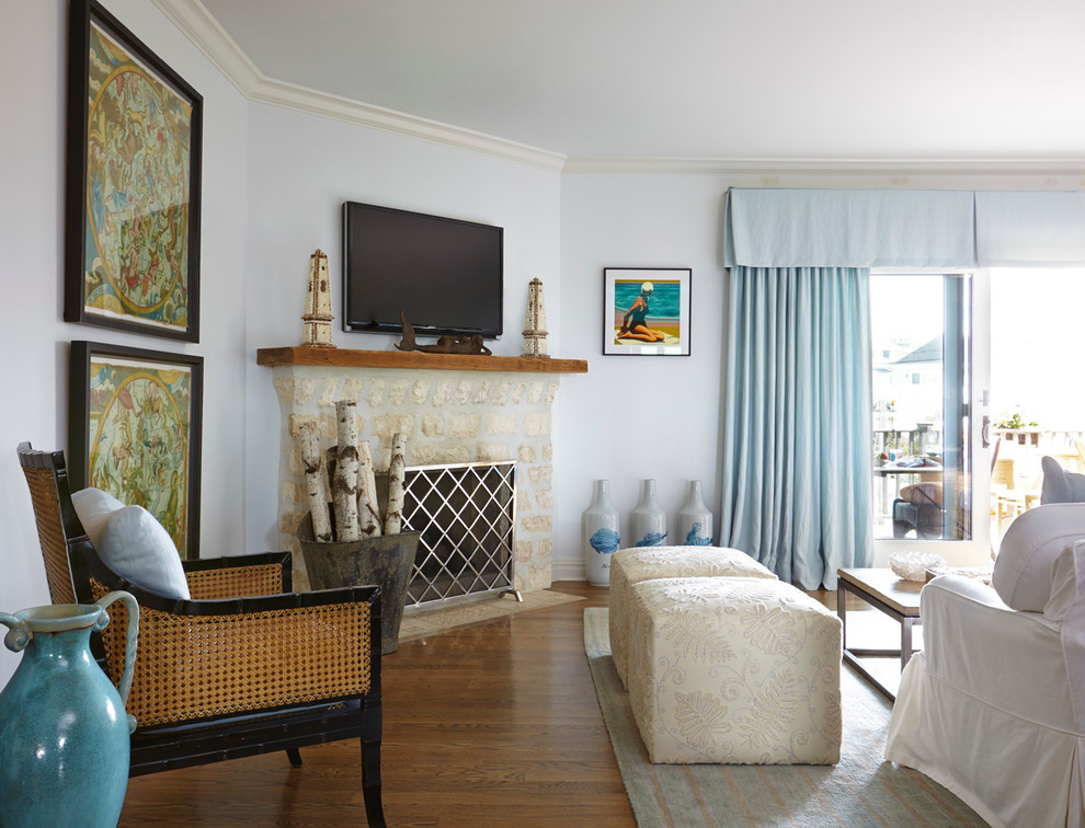 Imagen de salón abierto marinero grande con paredes blancas, suelo de madera en tonos medios, estufa de leña, marco de chimenea de piedra y televisor colgado en la pared
