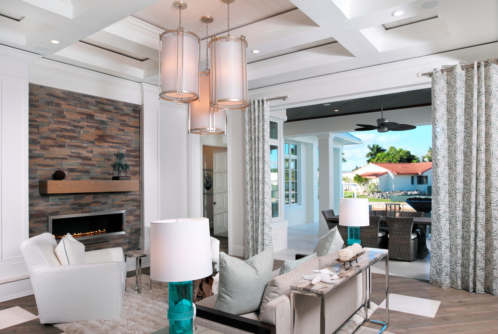 Mittelgroßes, Offenes Klassisches Wohnzimmer mit weißer Wandfarbe, braunem Holzboden, Gaskamin, Kaminumrandung aus Metall und TV-Wand in Miami