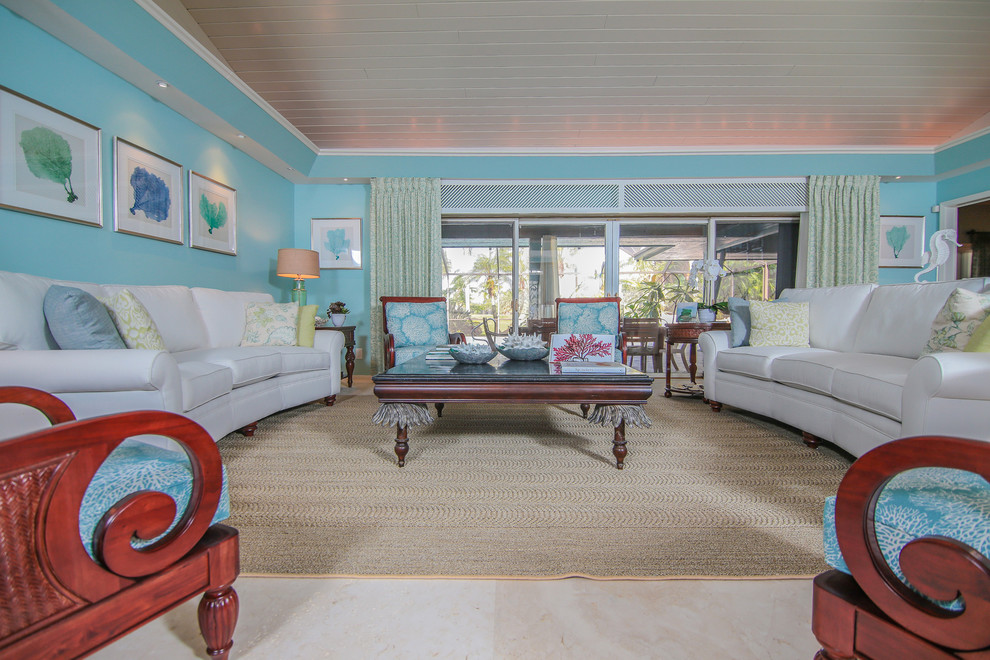 Imagen de salón para visitas abierto costero grande sin chimenea y televisor con paredes azules y suelo de travertino