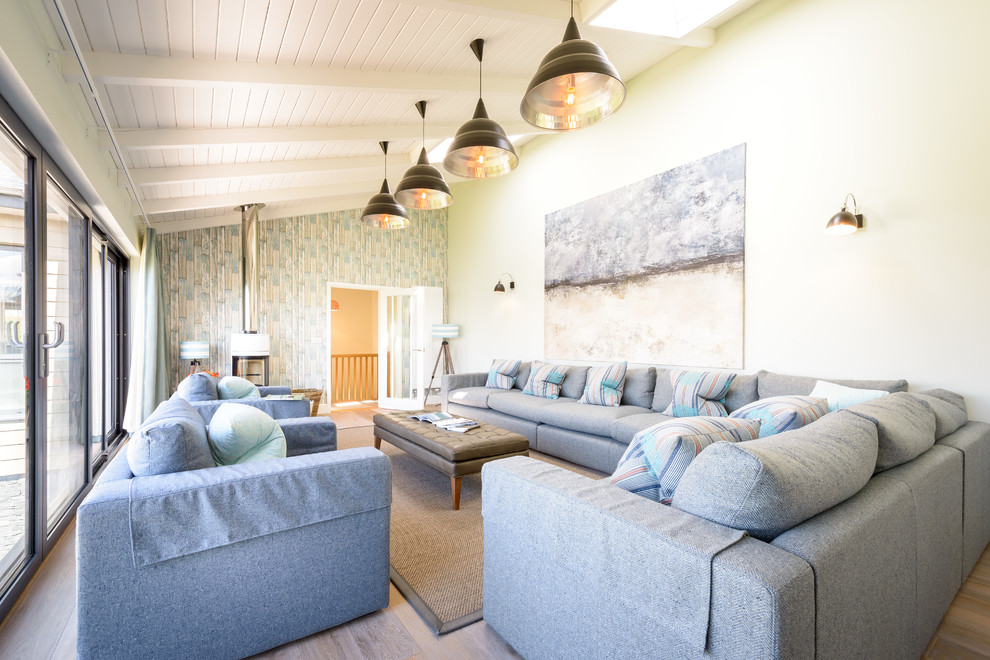 Immagine di un grande soggiorno stile marino chiuso con pareti beige, parquet scuro, stufa a legna e nessuna TV