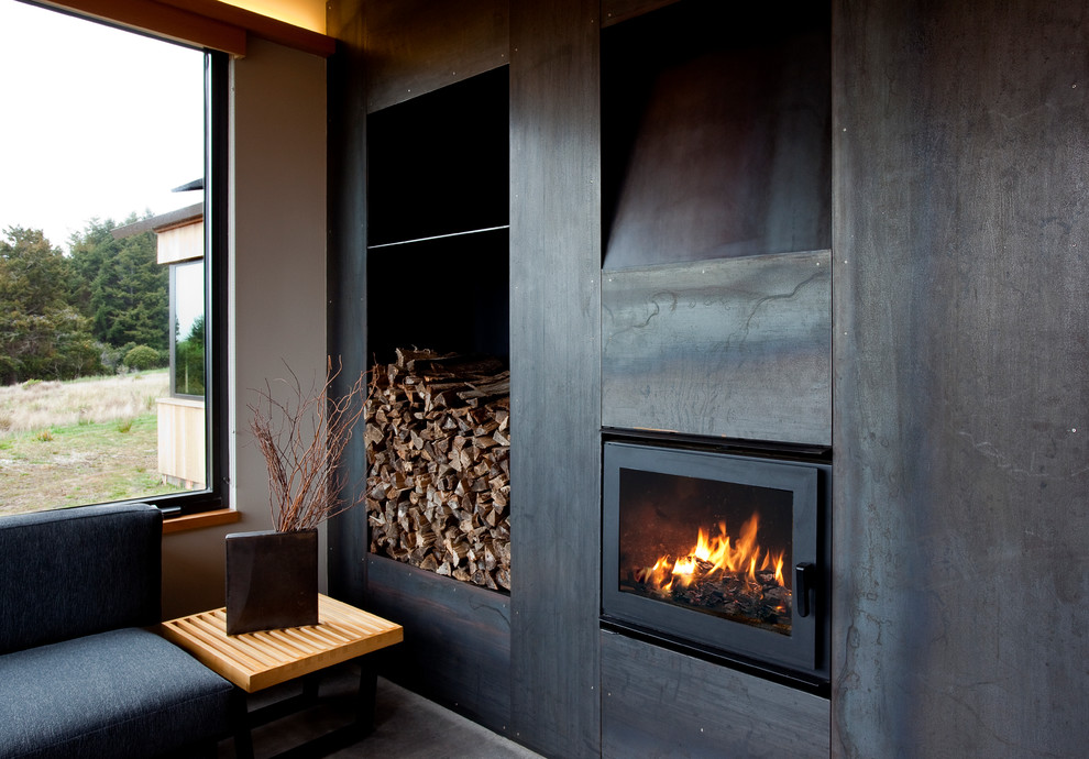 Imagen de salón cemento minimalista de tamaño medio sin televisor con todas las chimeneas y marco de chimenea de metal