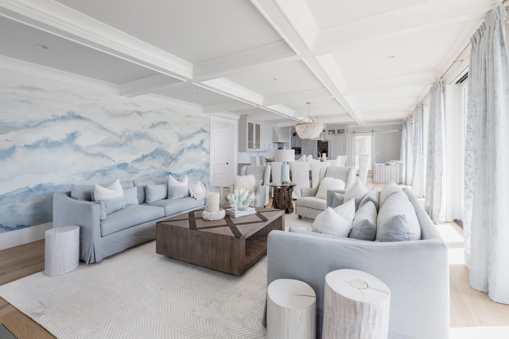 Ejemplo de salón abierto costero con paredes azules, suelo de madera clara y suelo beige