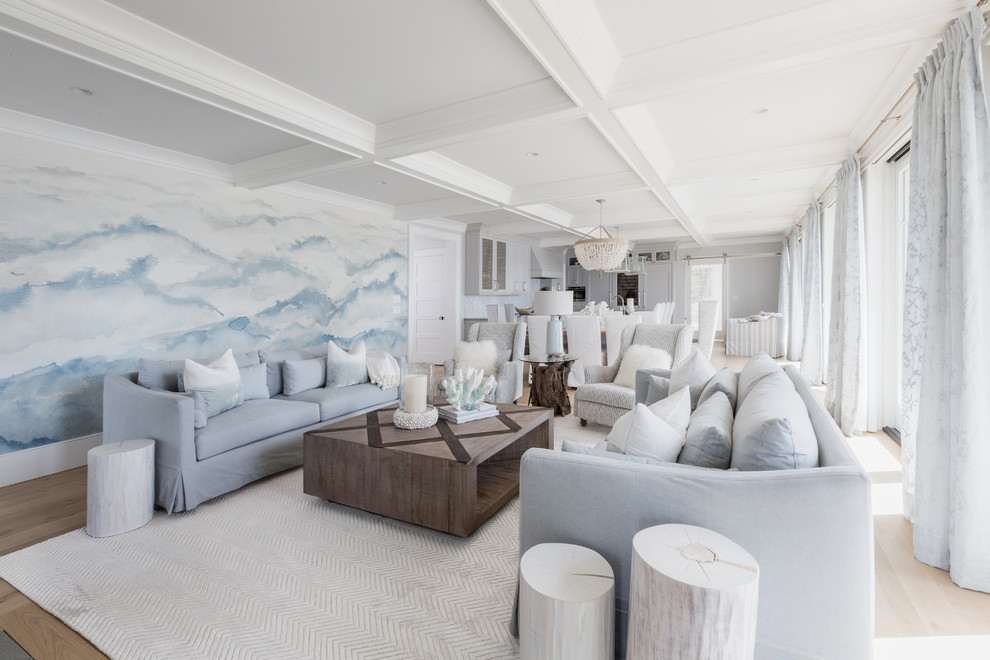 Immagine di un soggiorno stile marino aperto con pareti blu, parquet chiaro e pavimento beige
