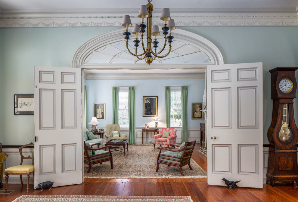 Ejemplo de salón para visitas cerrado tradicional con paredes azules y suelo de madera en tonos medios
