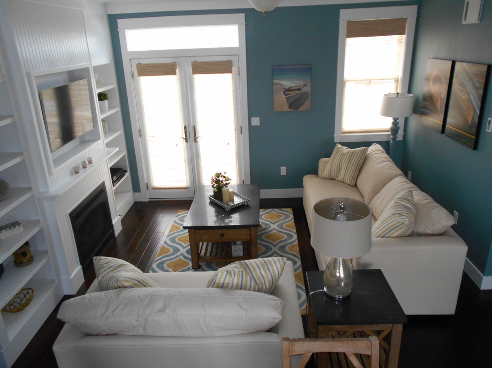 Mittelgroßes, Offenes Maritimes Wohnzimmer mit blauer Wandfarbe, dunklem Holzboden, Kamin, Kaminumrandung aus Holz und Multimediawand in Seattle