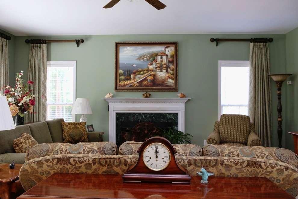 Exemple d'un salon chic de taille moyenne et ouvert avec un mur vert, une cheminée standard, un manteau de cheminée en bois, un téléviseur encastré, un sol en bois brun et un sol marron.