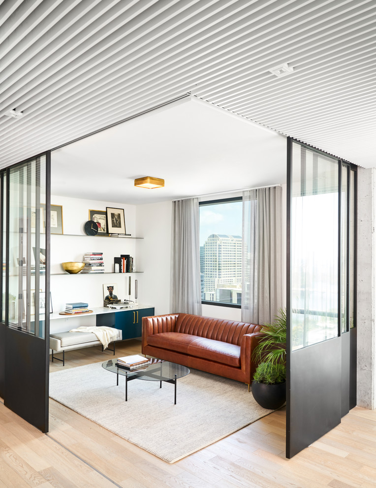 Modelo de salón para visitas abierto actual sin televisor con paredes blancas, suelo de madera clara y suelo beige