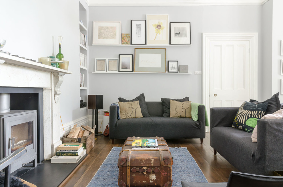Источник вдохновения для домашнего уюта: гостиная комната в современном стиле с серыми стенами и печью-буржуйкой
