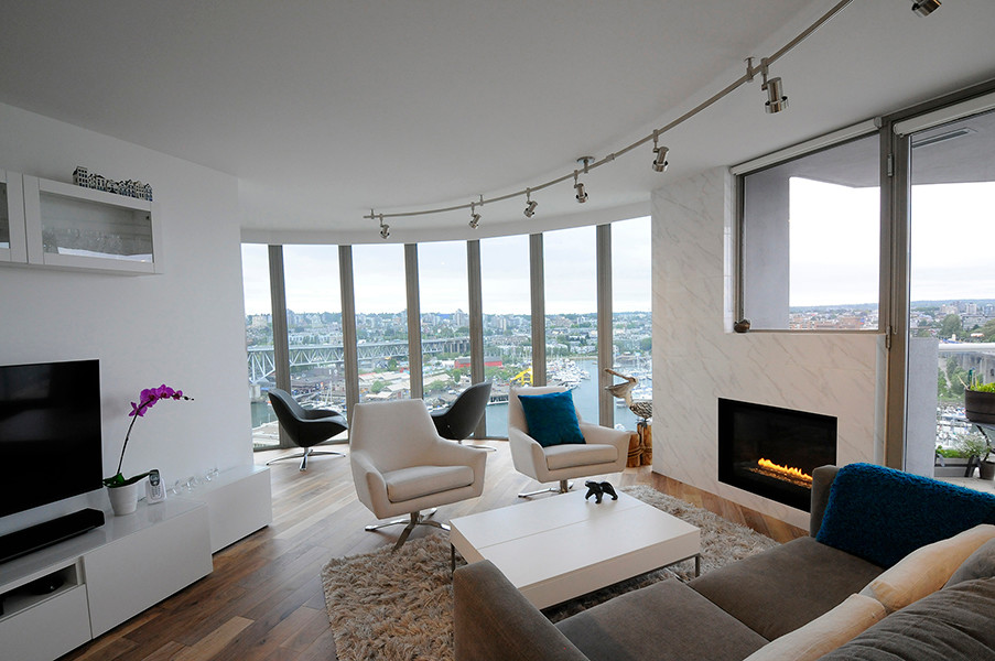 Diseño de salón abierto contemporáneo grande con paredes blancas, suelo de madera en tonos medios, chimenea lineal, marco de chimenea de baldosas y/o azulejos, televisor independiente y suelo marrón