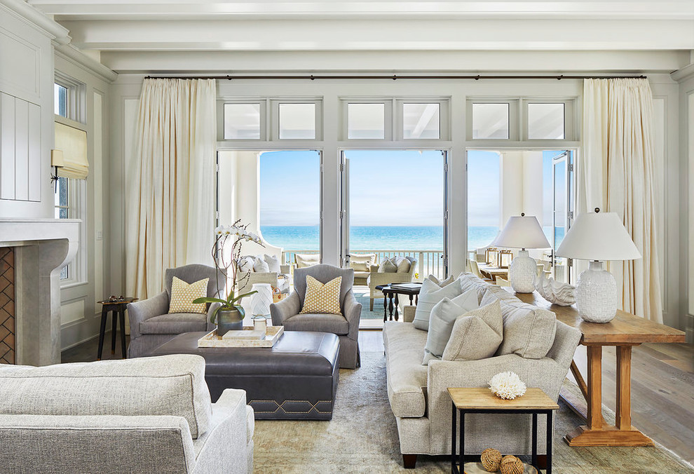 Стильный дизайн: гостиная комната в морском стиле с белыми стенами, светлым паркетным полом, стандартным камином и коричневым полом - последний тренд