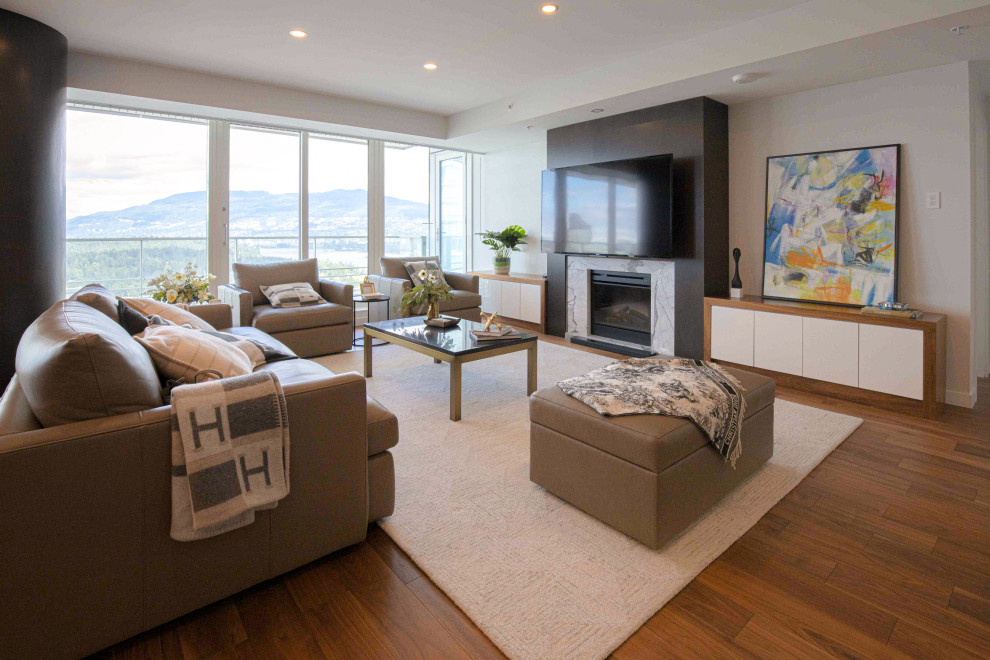 Inspiration for a contemporary open plan living room in Vancouver with grey walls, medium hardwood flooring, a standard fireplace, a wall mounted tv and brown floors.