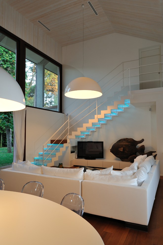 Источник вдохновения для домашнего уюта: открытая гостиная комната в современном стиле с белыми стенами, темным паркетным полом и отдельно стоящим телевизором