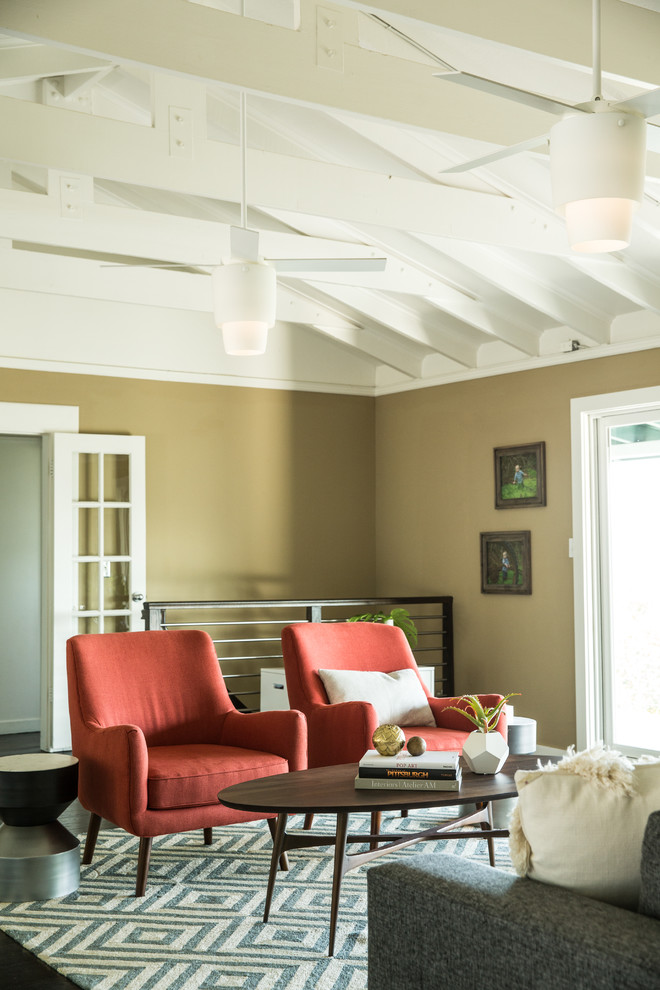 Ispirazione per un soggiorno moderno con pareti beige, parquet scuro, camino classico e cornice del camino in mattoni