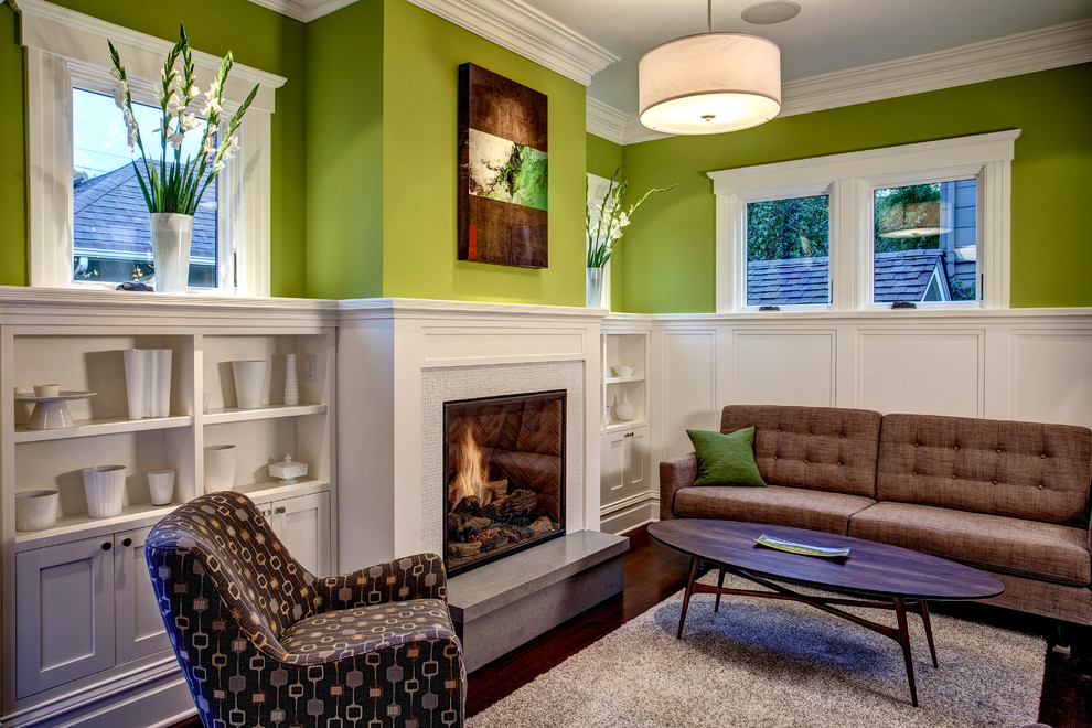 Mittelgroßes Klassisches Wohnzimmer mit grüner Wandfarbe, dunklem Holzboden, Kamin und Kaminumrandung aus Holz in Seattle