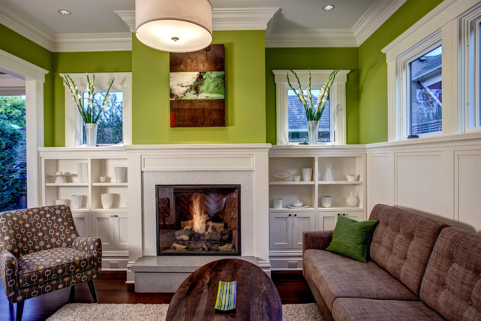 Exempel på ett mellanstort klassiskt vardagsrum, med gröna väggar, mörkt trägolv, en standard öppen spis och en spiselkrans i trä