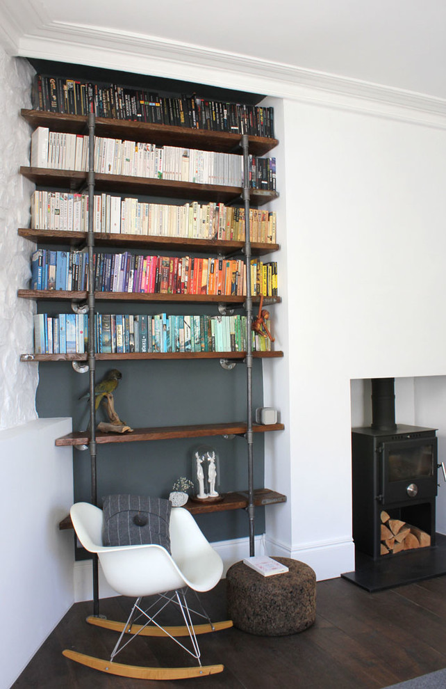 Idée de décoration pour un salon design avec une bibliothèque ou un coin lecture, un mur blanc et parquet foncé.