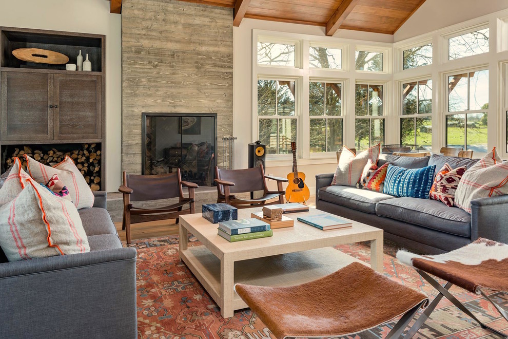 Photo of a large farmhouse open plan living room in San Francisco with white walls, light hardwood flooring, a standard fireplace, a concrete fireplace surround, no tv and brown floors.