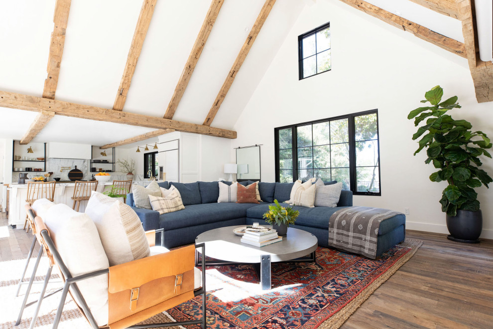 This is an example of a rural open plan living room in San Francisco with white walls, dark hardwood flooring and brown floors.