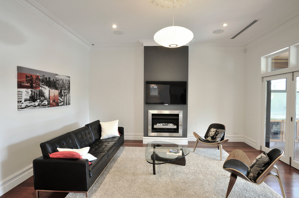 Modern inredning av ett vardagsrum, med vita väggar, mörkt trägolv, en standard öppen spis, en spiselkrans i metall och en väggmonterad TV