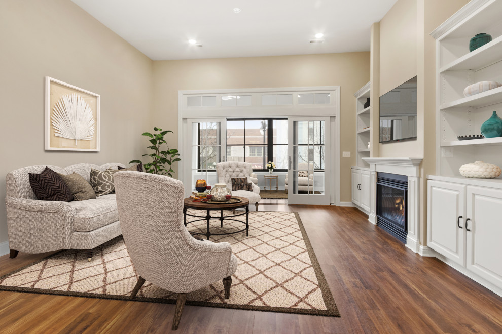 Huge elegant open concept vinyl floor and brown floor living room photo in Milwaukee with beige walls, a standard fireplace, a wood fireplace surround and a wall-mounted tv