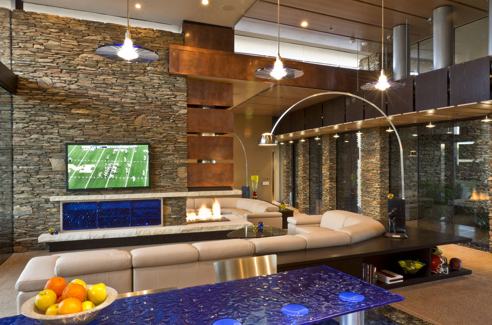 Huge southwest open concept concrete floor and beige floor living room photo in Phoenix with a wall-mounted tv, a two-sided fireplace and a stone fireplace